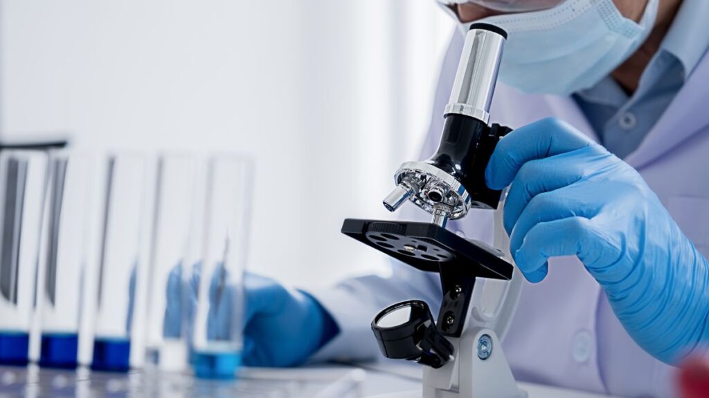 A researcher operating a microscope in a laboratory.